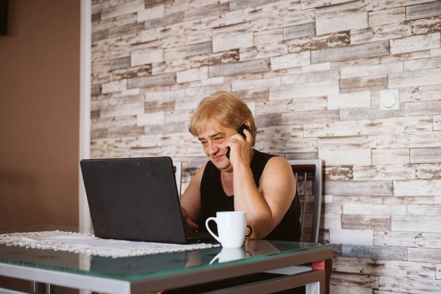 Bild ältere Frau sitzt vor dem Laptop