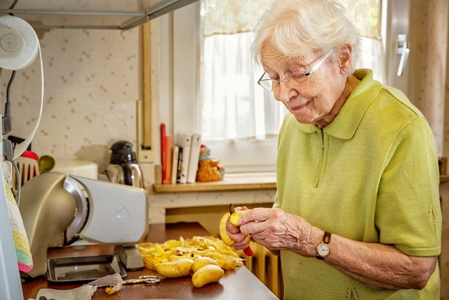 Bild Frau schält Kartoffeln