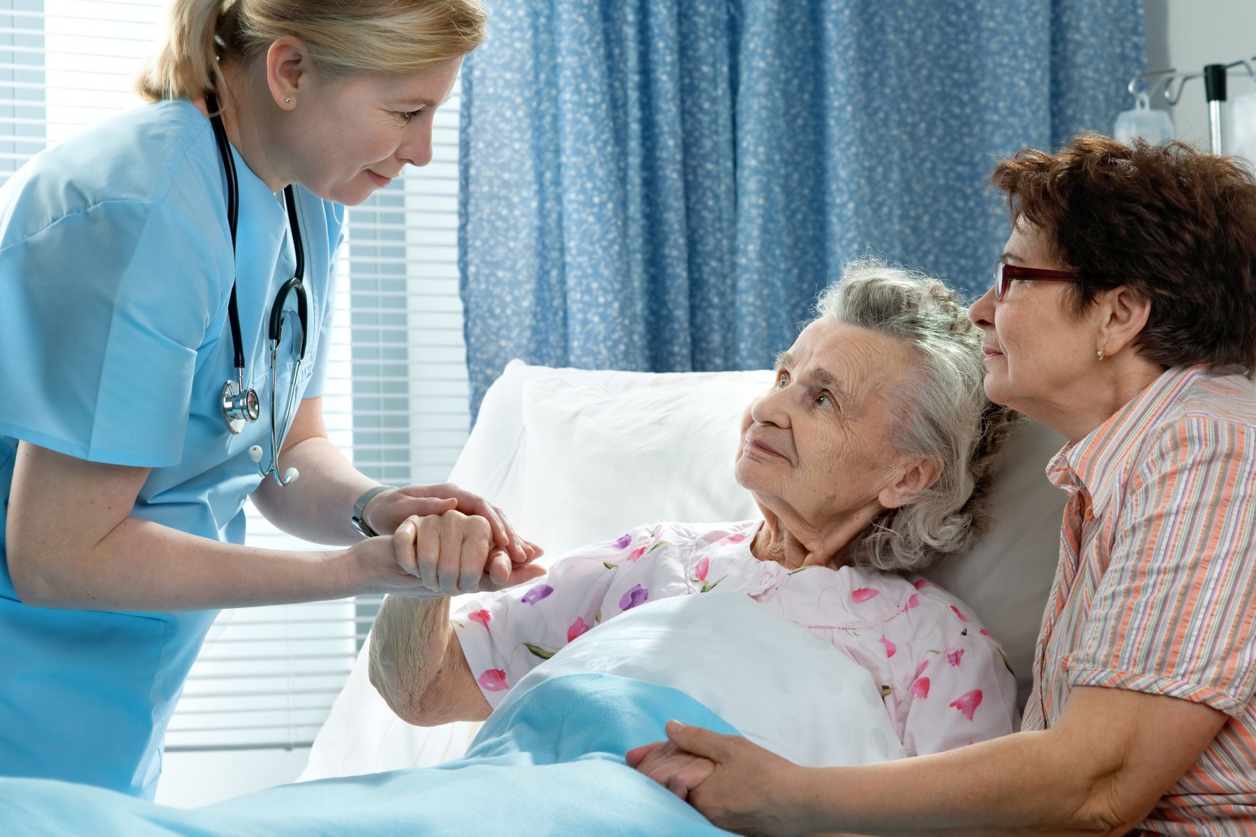 Bild Pflegerin hält Hand einer Patientin
