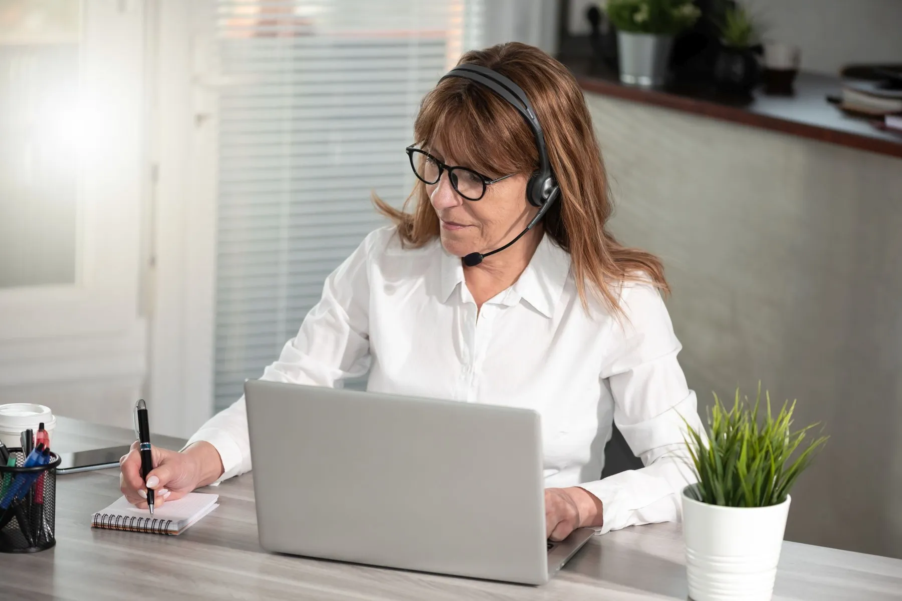 Bild: Frau mit Headset am Laptop