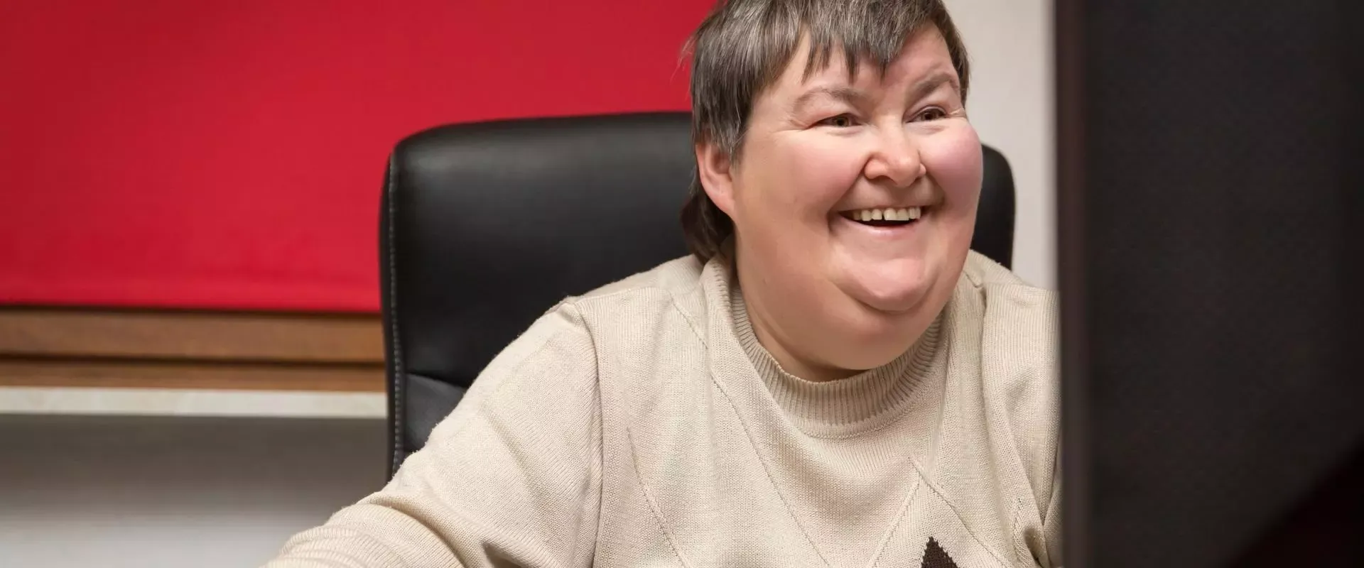 Frau mit einer Behinderung bedient einen PC
