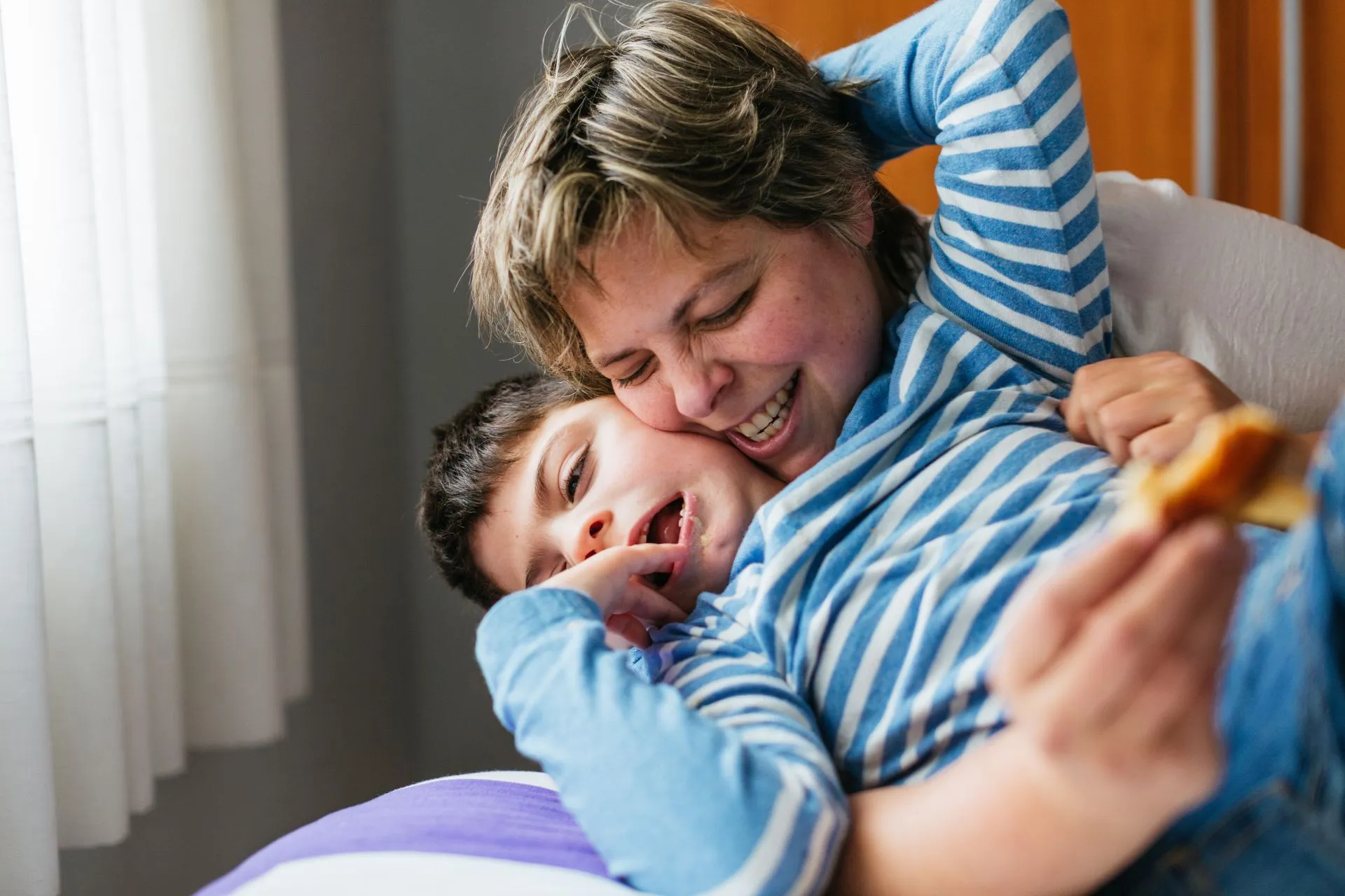 Mutter kuschelt mit behindertem Sohn
