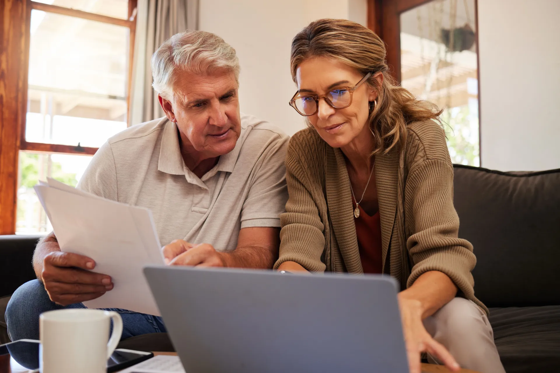 Paar sitzt gemeinsam vor einem Laptop bei Recherchearbeiten