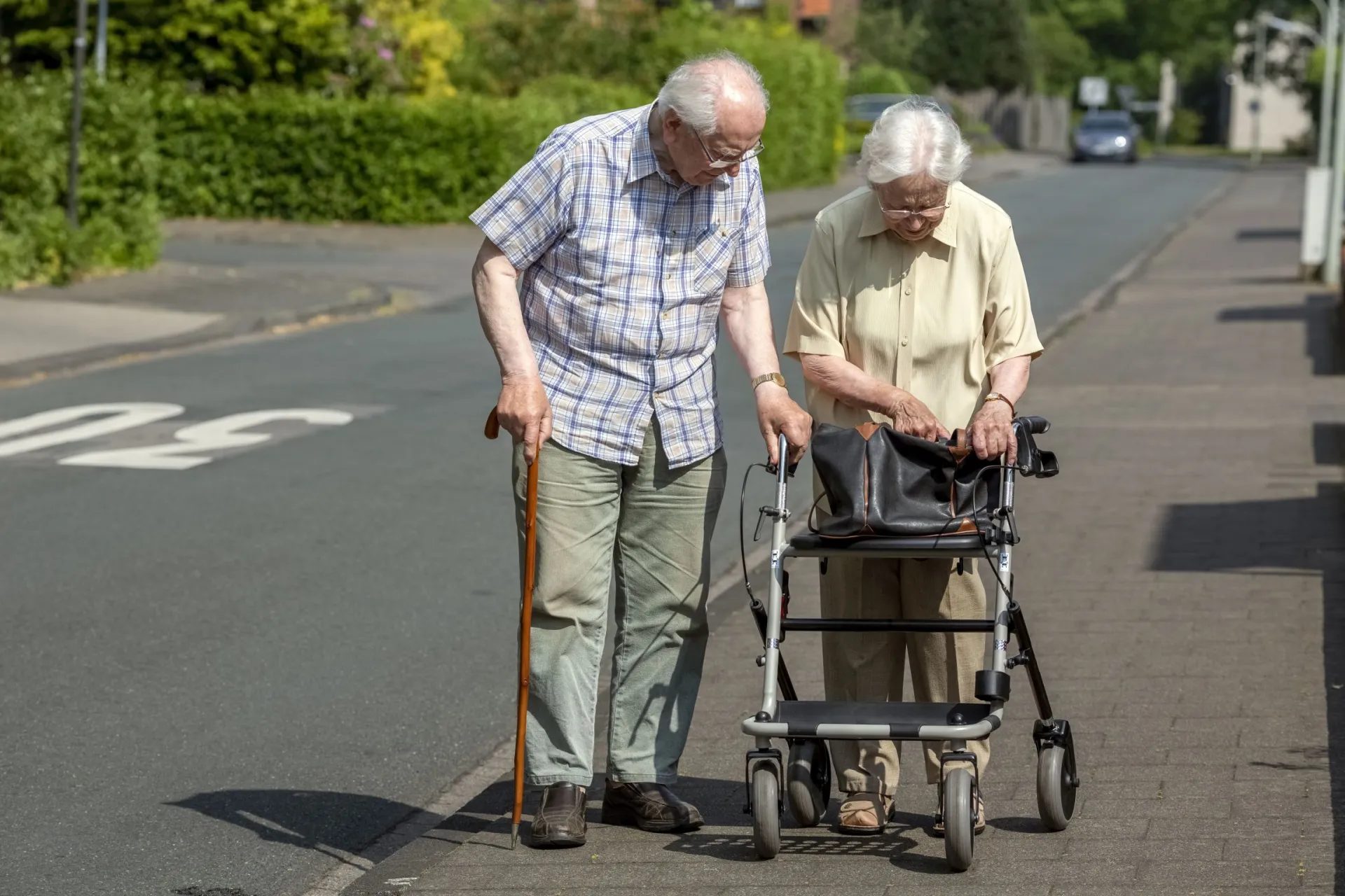 Älteres Paar geht mit Rollator spazieren