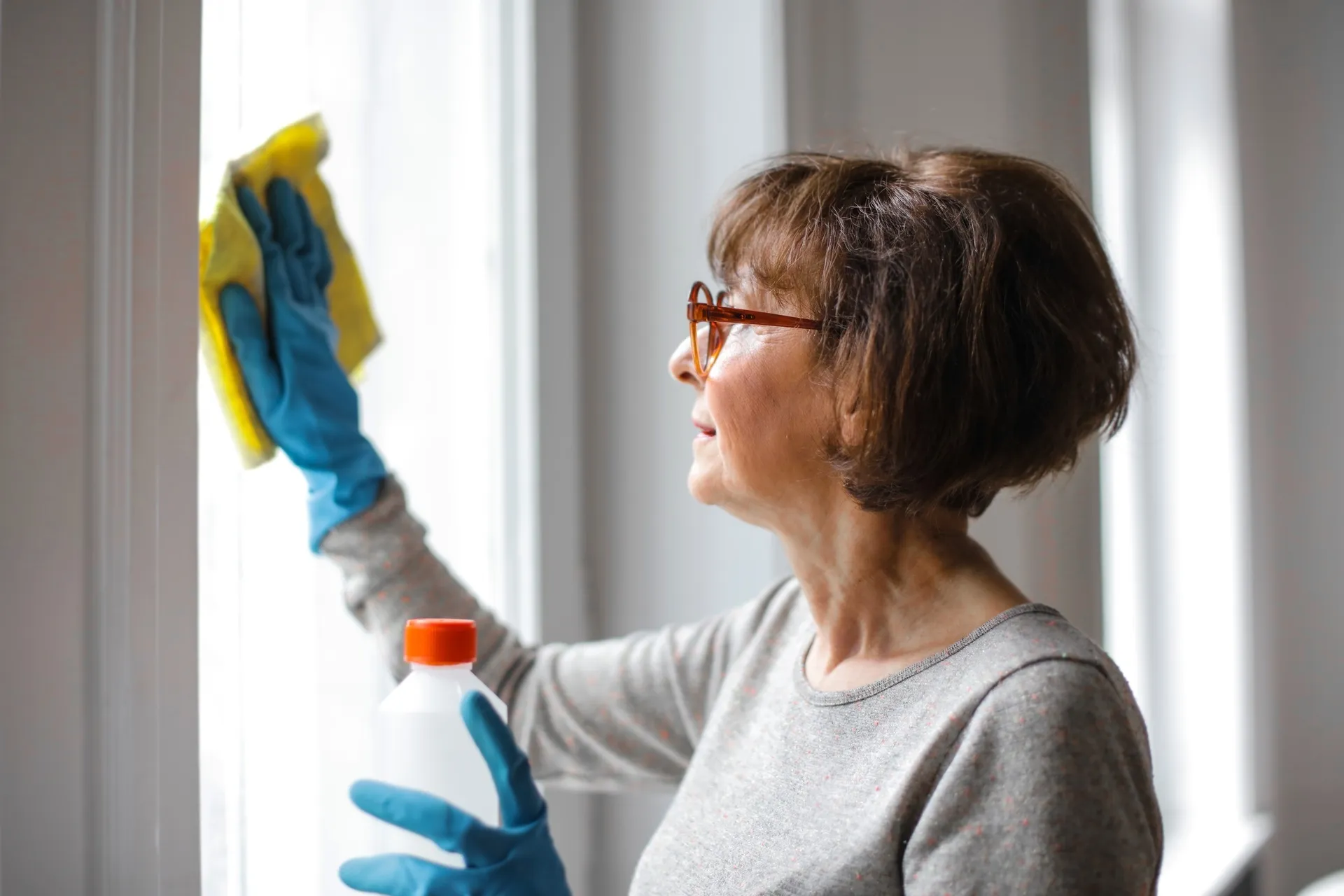 Frau putzt Fenster