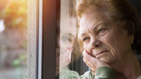 Bild einer depressiven Frau am Fenster