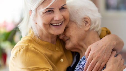 Bild: Frau umarmt Seniorin