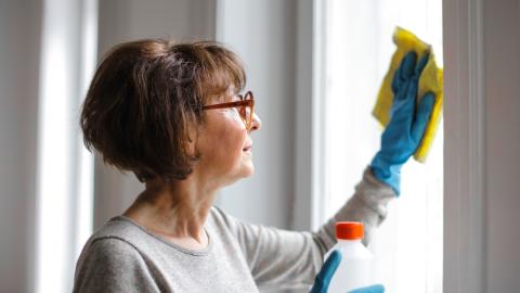 Frau putzt Fenster