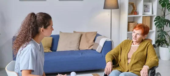 Bild Pflegerin bespricht sich mit Frau im Rollstuhl