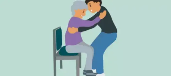 Ein Mann hilft einer älteren Dame vom Stuhl aufzustehen