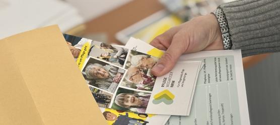 Frauenhand hält Briefumschlag