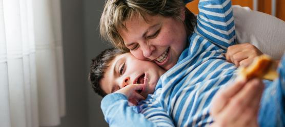 Mutter kuschelt mit behindertem Sohn