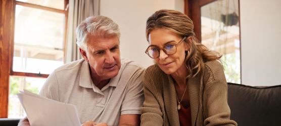 Paar sitzt gemeinsam vor einem Laptop bei Recherchearbeiten