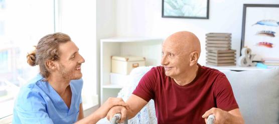 Pfleger mit Mann am Rolator