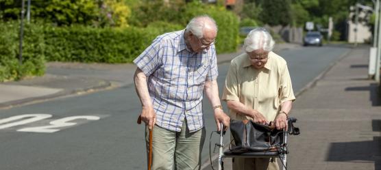 Älteres Paar geht mit Rollator spazieren