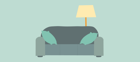 Sofa mit zwei Kissen und einer Stehlampe im Hintergrund