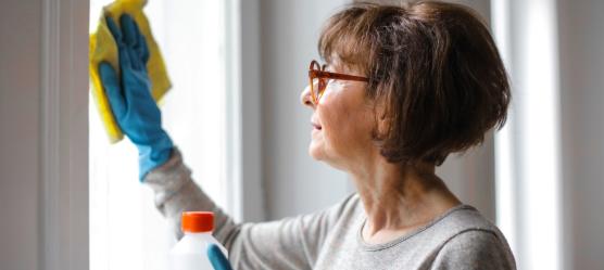 Frau putzt Fenster