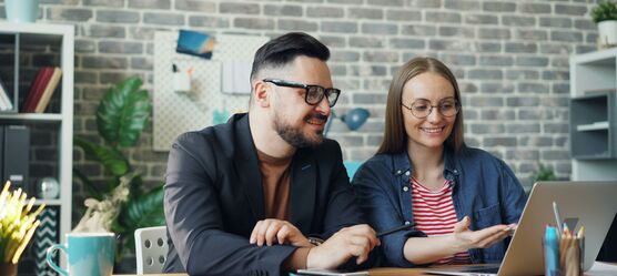 Frau und Mann sitzen vor einem Laptop