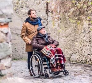Bild Mann schiebt Rentner im Rollstuhl