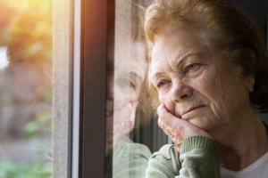 Bild einer depressiven Frau am Fenster