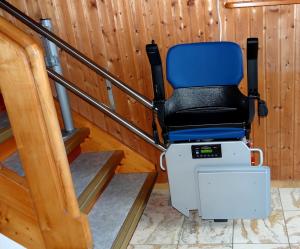 Eingebauter blauer Treppenlift am Treppenanfang einer Wohnung, ohne Person